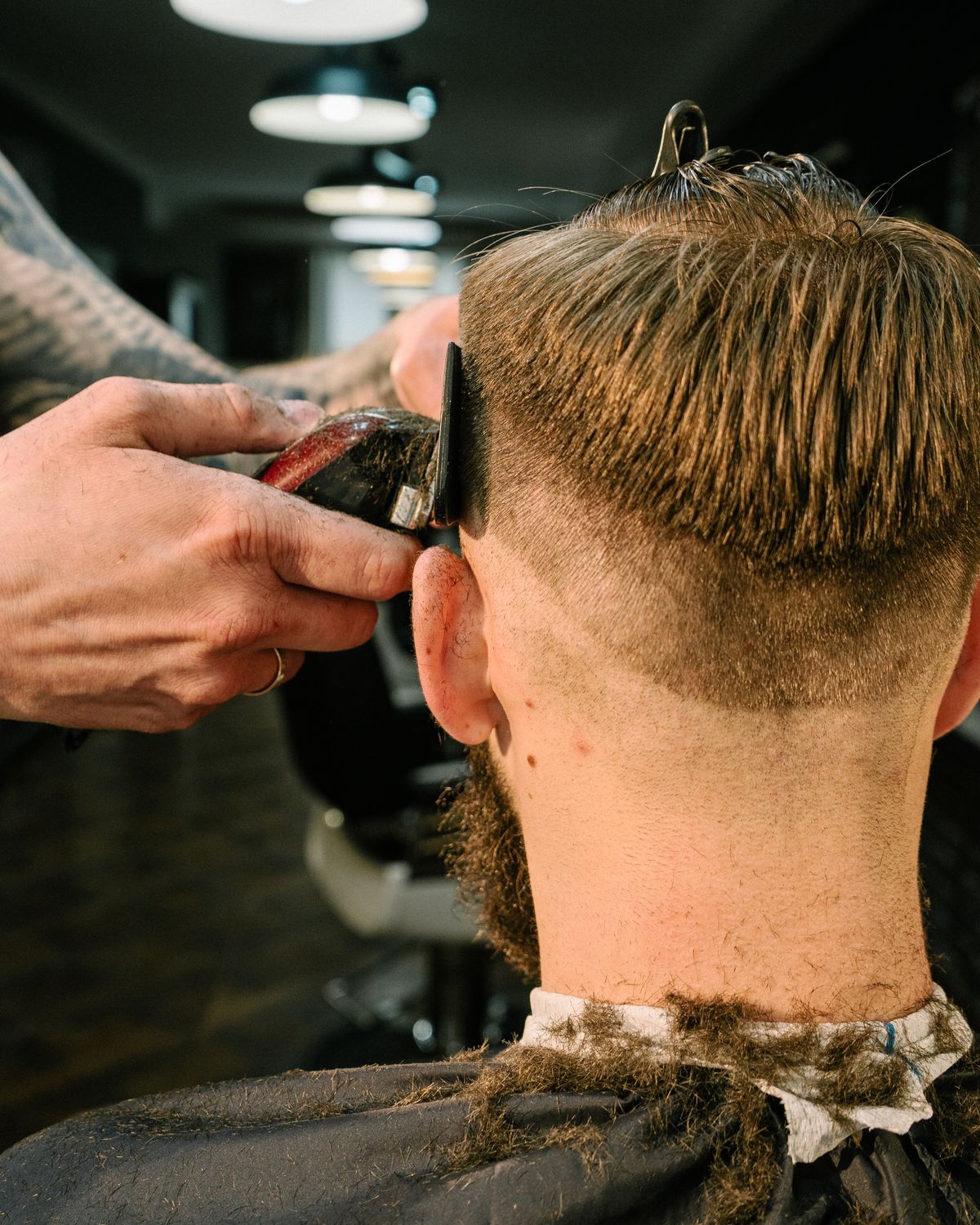 Barber giving a precision skin fade haircut in a modern barbershop